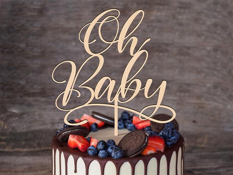 Topper en bois Oh Baby planté sur un gâteau de baby shower