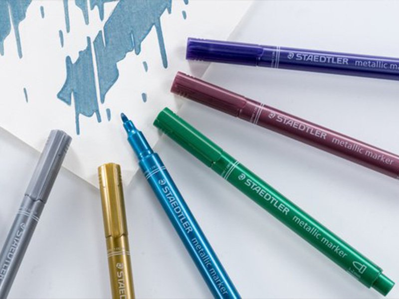 Feutres à encre métallique or, argent et couleurs sur fond blanc